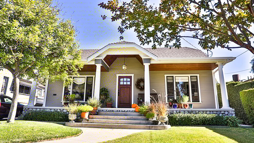 View of the front of a S. Cali home with blue sky and green grass